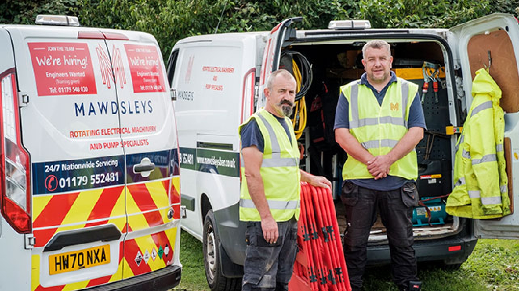 2 engineers in hi vis jackets in front of two Mawdsleys Vans