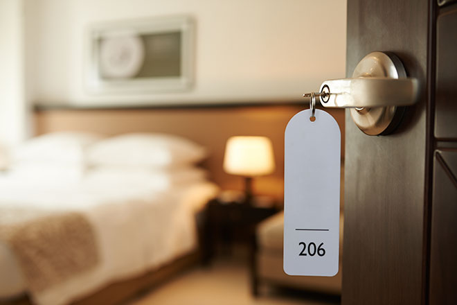 Image of a hotel room key in the open room doorway