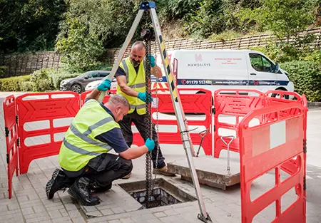 An image demonstrating two of our engineers fixing a sewage pump